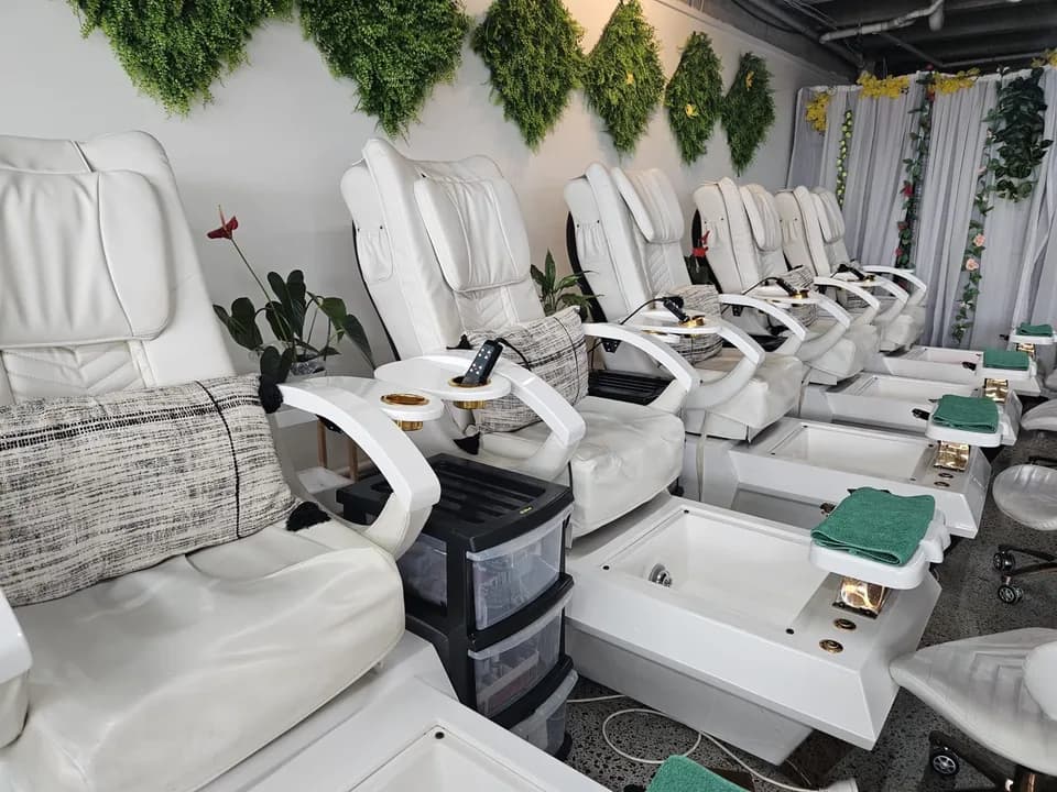 Row of pedicure spa massage chairs with a floral backdrop